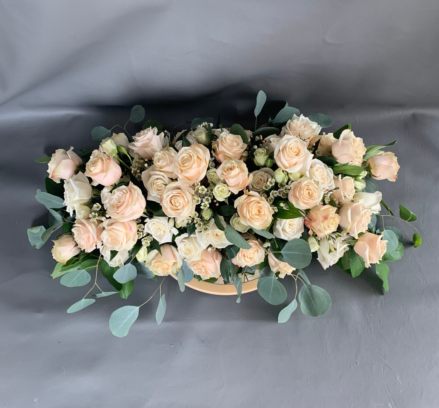 Bouquet of light pink roses with greenery on a gray background