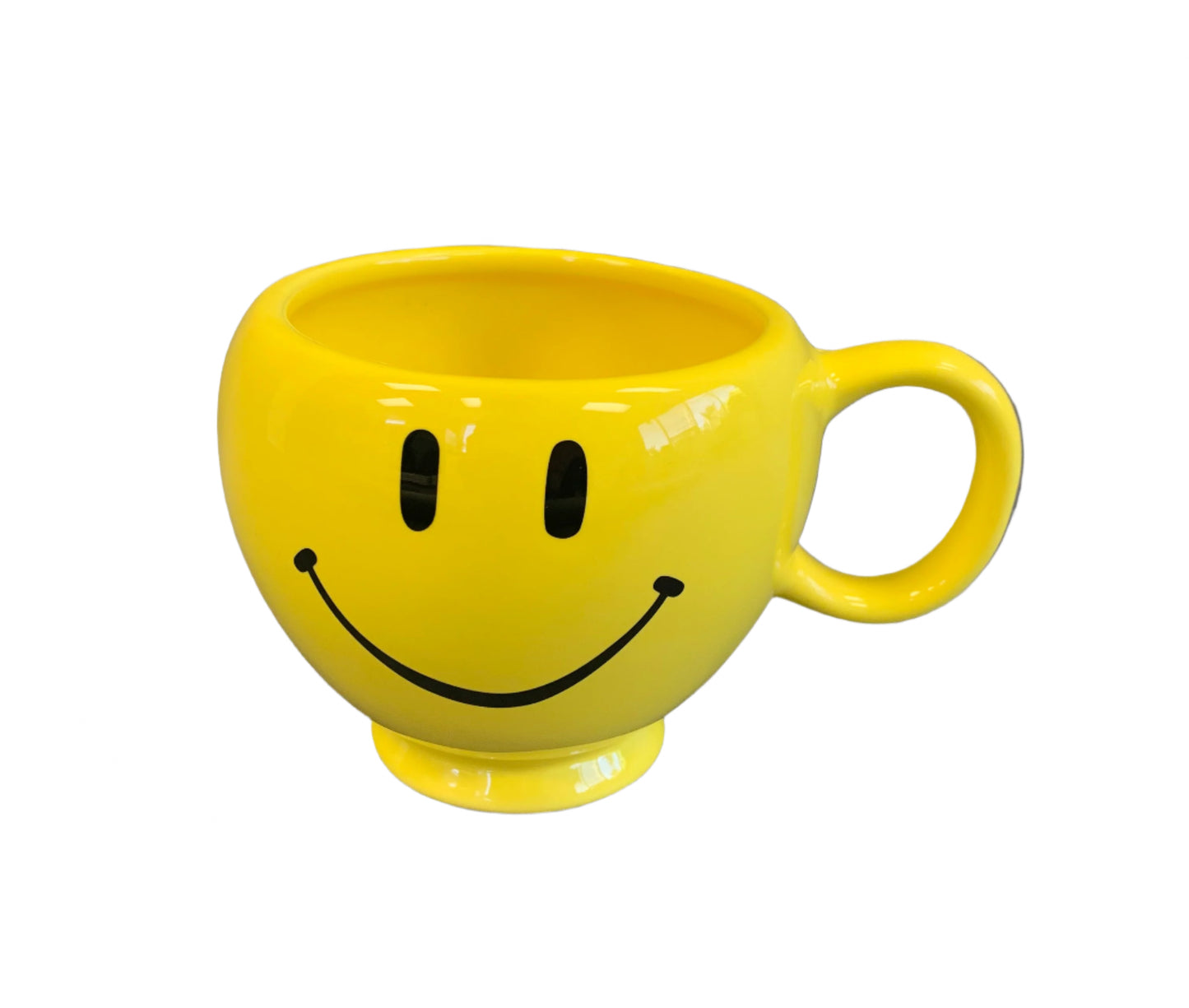 Yellow mug with a smiley face design on a gray background
