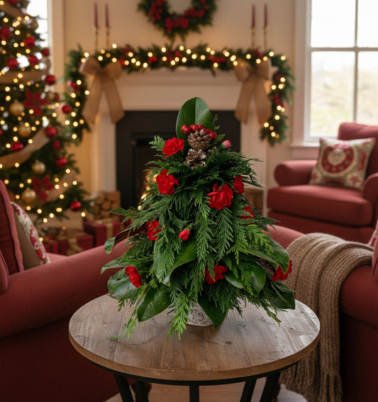Fresh greenery table arrangement shaped like Christmas tree with fresh flowers as decorations