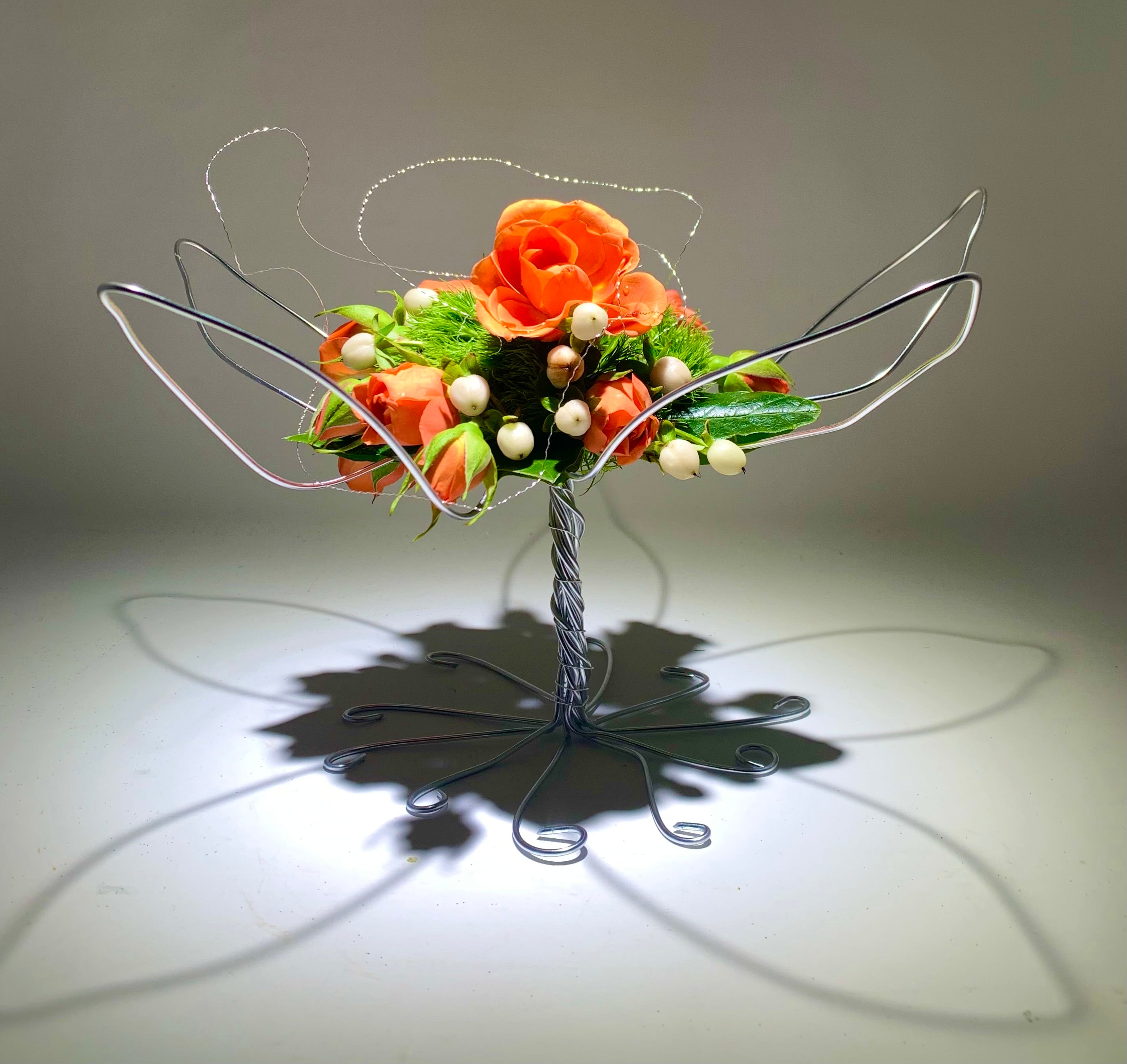Orange bouquet in artistic silver wire armature for wedding or as table decoration